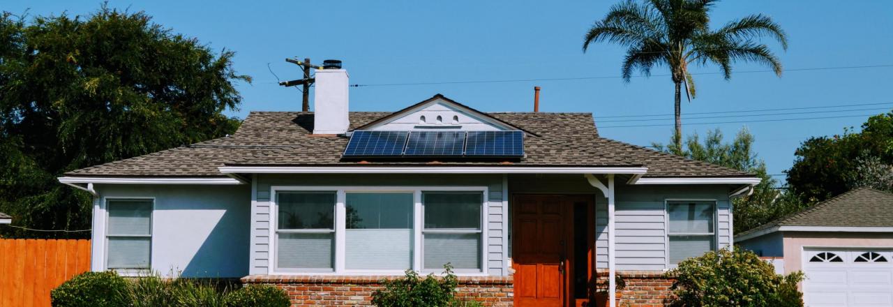Solar panels on roof of blue cottage in Los Angeles, CA