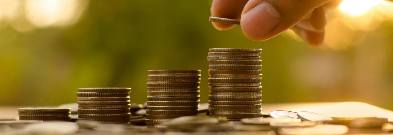 Quarters being stacked on wooden table Hand Stacking Coins