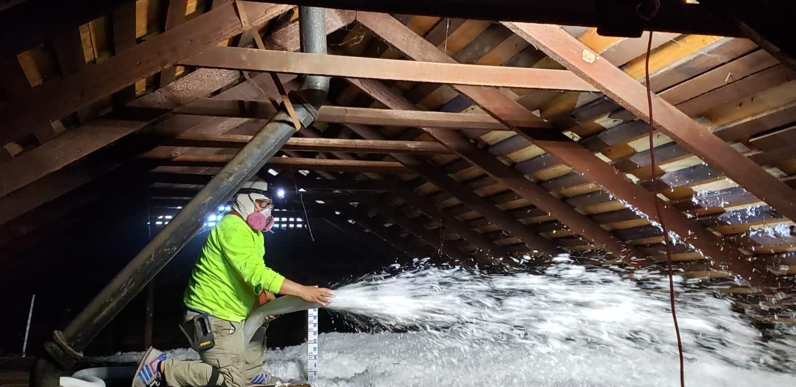 Greencat Technician Applying Blown Insulation In Attic