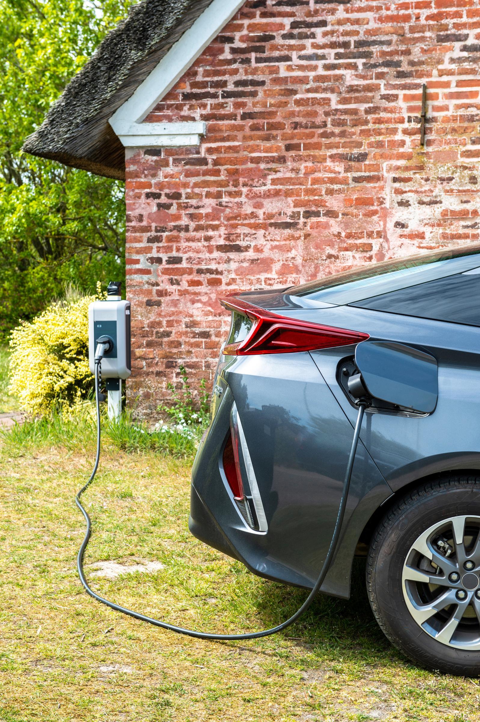 electric car charging in front of brick home