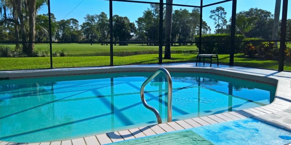 Beautiful indoor pool with a view of a lush and sunny back yard