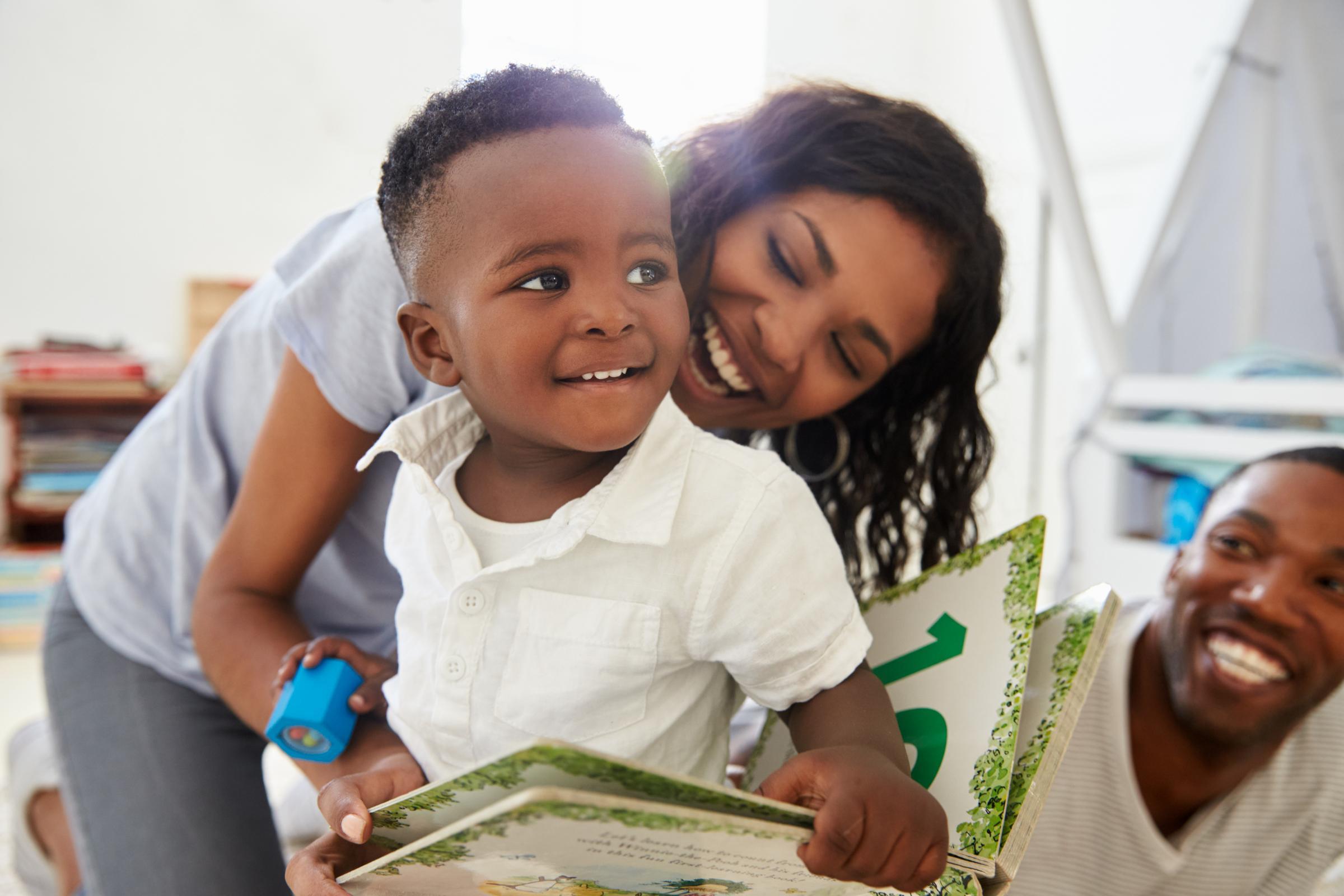 Happy family reading a book with a young child