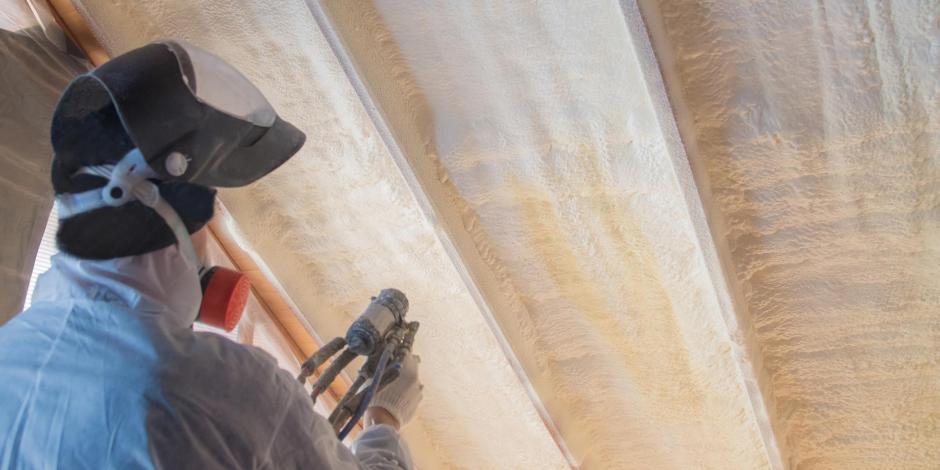 Worker Applying Spray Foam Insulation In Attic Worker Applying Spray Foam Insulation In Attic